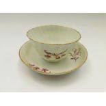 A Worcester tea bowl and saucer. Puce and gilt floral decorated, tea bowl has a twisted fluted body.