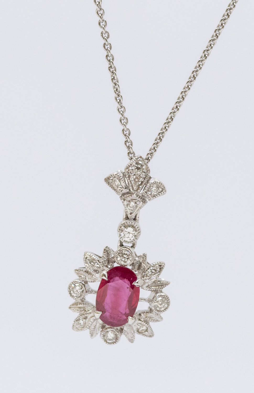 A ruby and diamond 18ct white gold pendant, comprising an oval mixed cut ruby approx 6 x 4mm, within