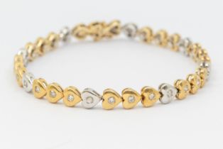 A diamond and 18ct gold two tone bracelet, comprising alternate rows of yellow and white heart