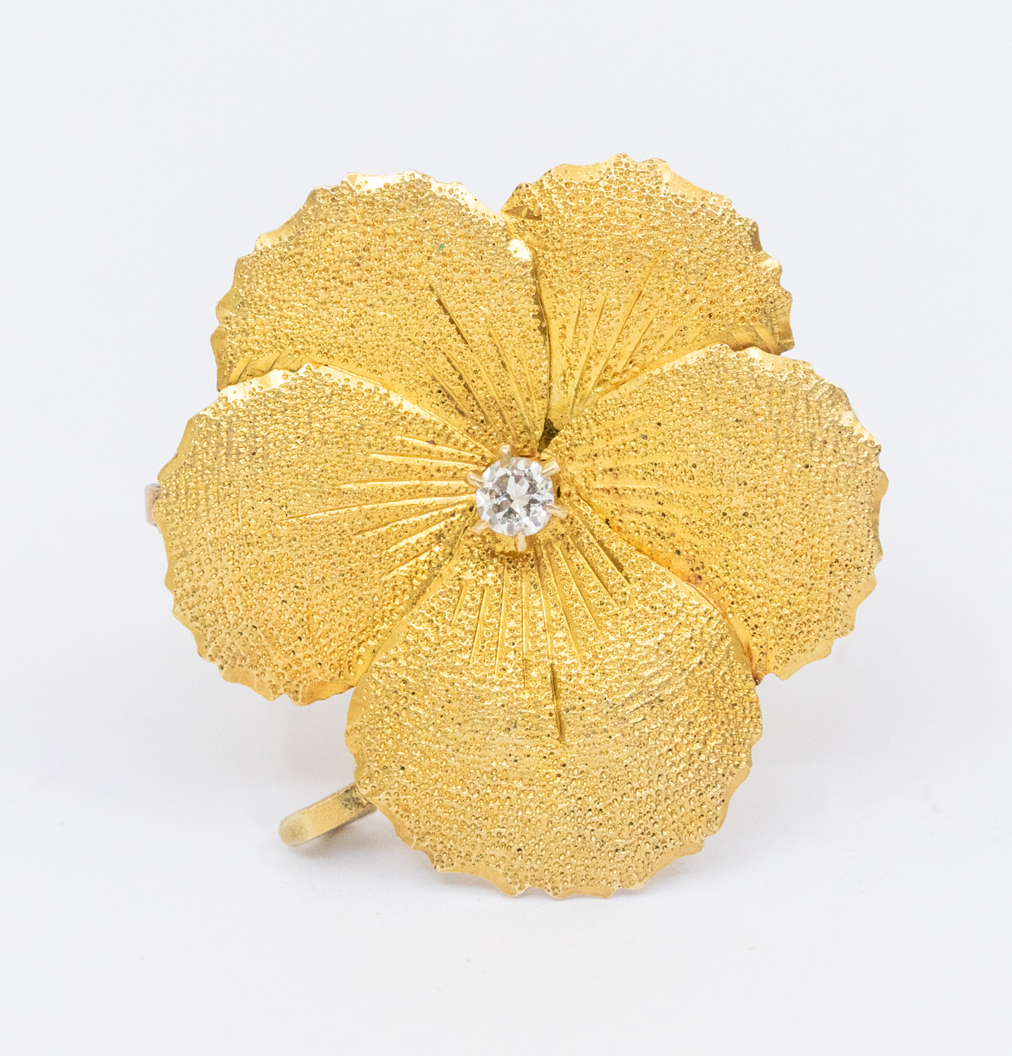 A diamond and gold flower brooch set with a single diamond approx 0.03ct, brooch diameter approx