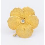 A diamond and gold flower brooch set with a single diamond approx 0.03ct, brooch diameter approx