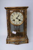 A late 19th century French 8-day mantel clock with brass and enamel detail and Arabic numerals.