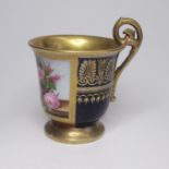 A continental blue ground porcelain chocolate cup with gilding around one side and a floral