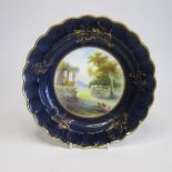 A Royal Worcester Plate with a deep Blue and gilt ground border and scalloped rim. The centre