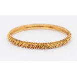 A 22ct gold bangle with popcorn style decoration, width approx 6mm, internal diameter approx 62mm,