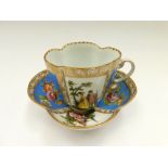 A Dresden quatrefoil cup and saucer with two blue panels painted with floral sprays and two panels