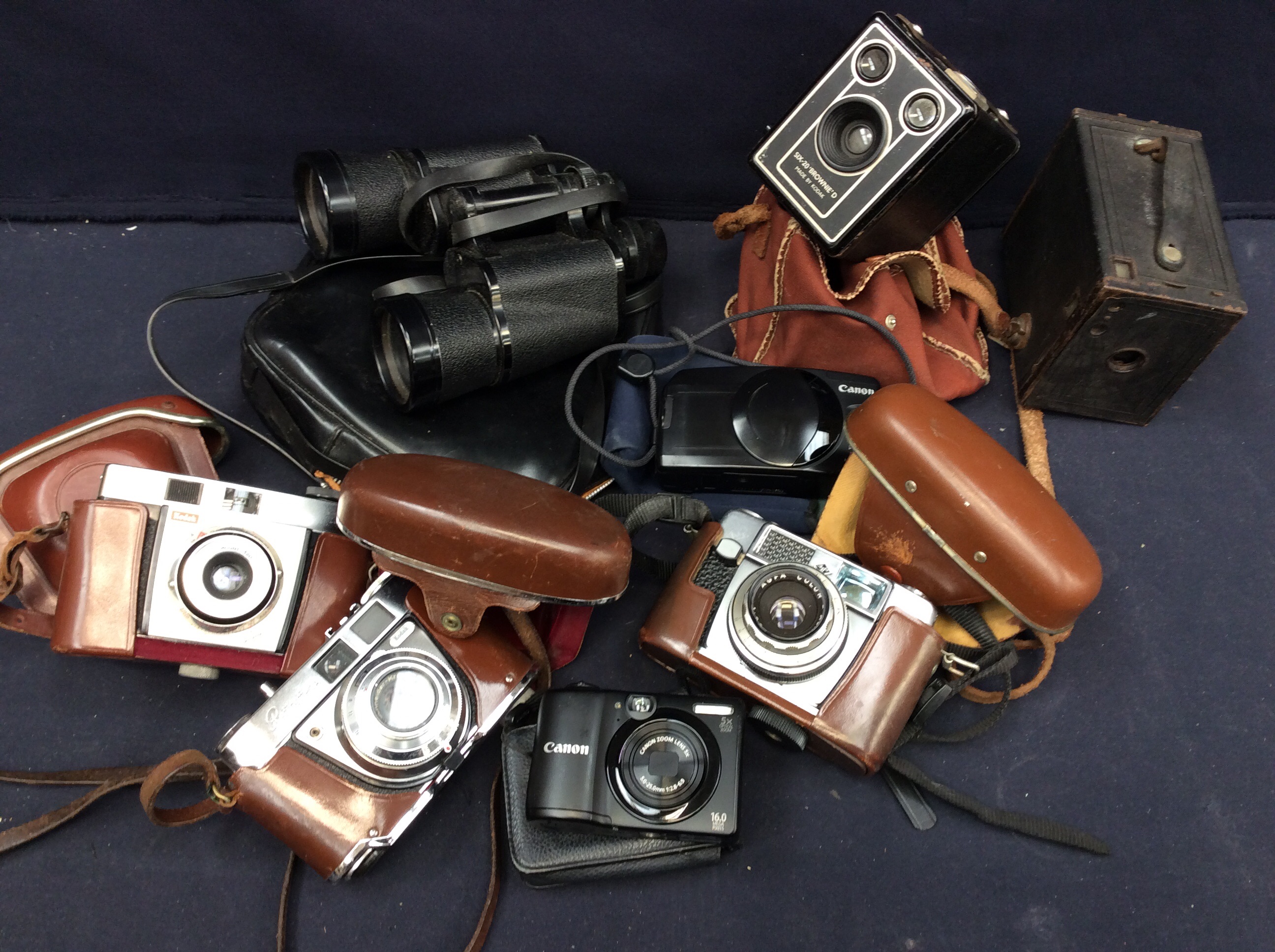 A collection of mid 20th Century cased cameras and a pair of binoculars.
