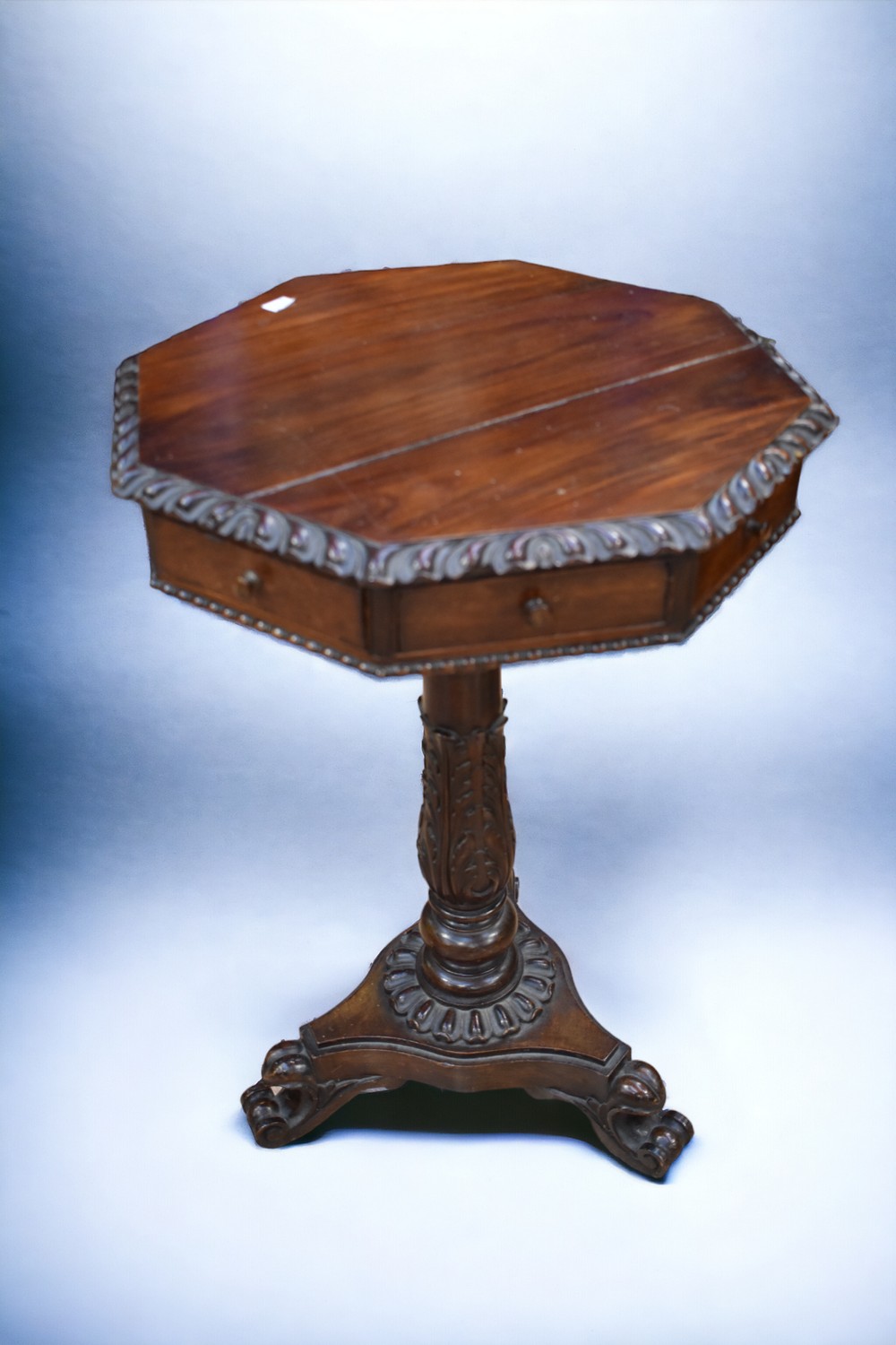 An octagonal occasional table on tripod feet, in mahogany, crack to top, missing one drawer