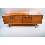 A mid 1970s teak G plan sideboard with three opening cupboard doors and four drawers, 206cm L x 46cm