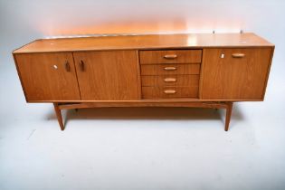 A mid 1970s teak G plan sideboard with three opening cupboard doors and four drawers, 206cm L x 46cm