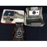 A mid 20th Century cased Rolleiflex camera, a mid 20th Century Eumig of Austria cine camera and a