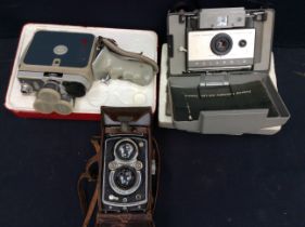 A mid 20th Century cased Rolleiflex camera, a mid 20th Century Eumig of Austria cine camera and a
