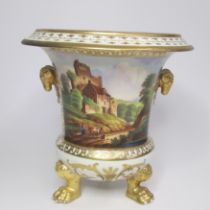 An English porcelain vase with twin ram’s mask handles and lions paw feet and painted with a country