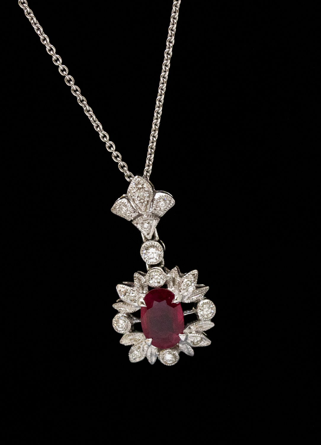 A ruby and diamond 18ct white gold pendant, comprising an oval mixed cut ruby approx 6 x 4mm, within - Image 2 of 2
