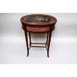 An Edwardian oval glazed with inlayed top collectors cabinet on sabre legs.