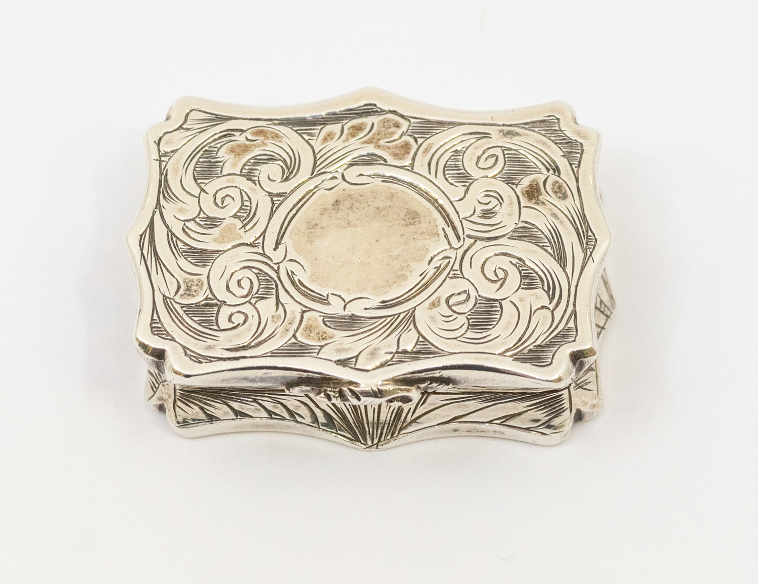 An early Victorian silver shaped rectangular vinaigrette, wavy border, the entire engraved with