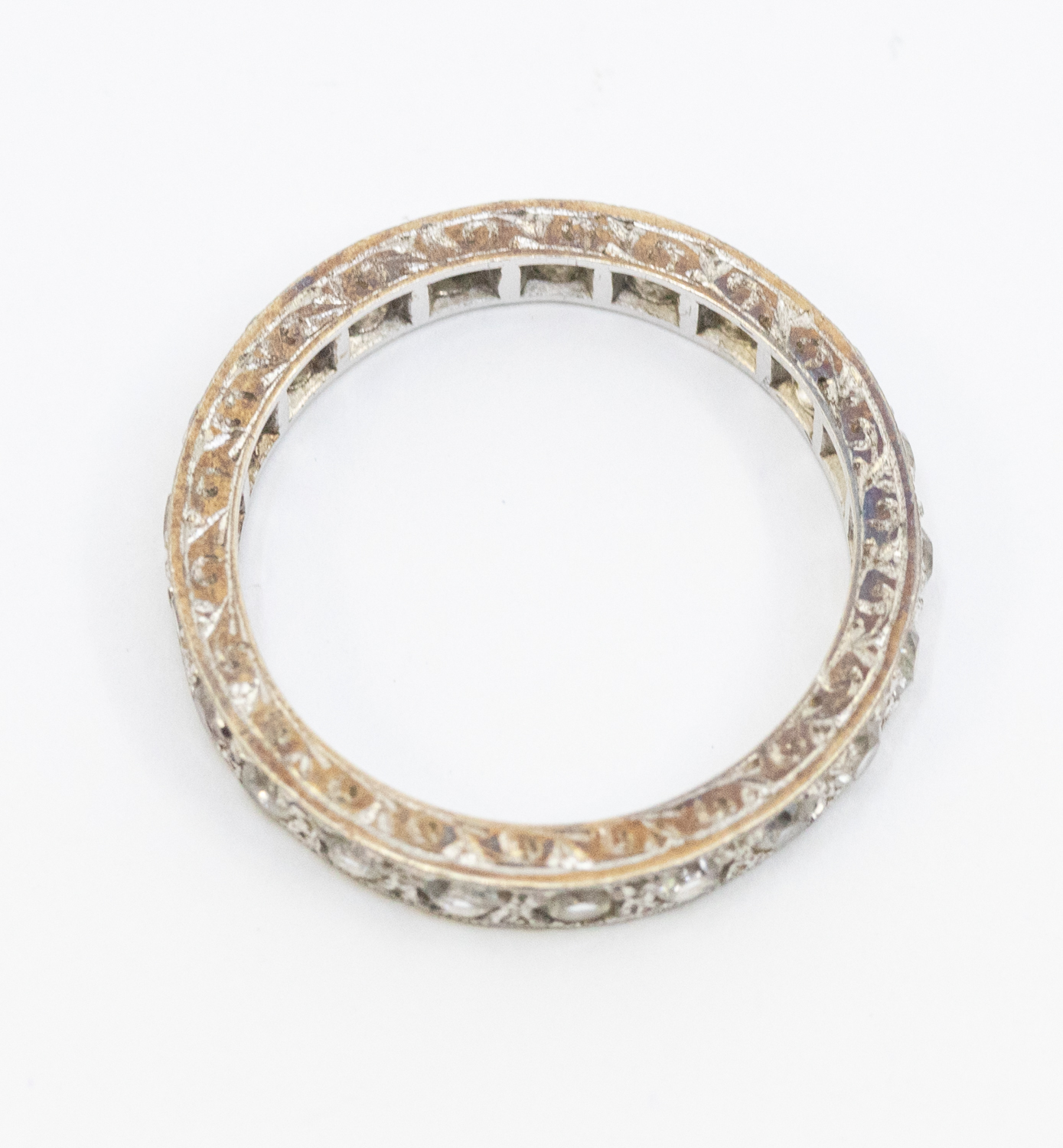 A stone set white metal eternity ring, width approx 3mm, size K1/2, unmarked, engraved mount, - Image 2 of 2