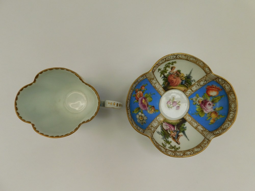 A Dresden quatrefoil cup and saucer with two blue panels painted with floral sprays and two panels - Image 2 of 2