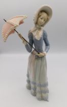 A Lladro figure of a lady with a parasol.