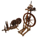 Two antique spinning wheels, a table-top example and a free-standing example. The table-top spinning