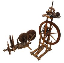 Two antique spinning wheels, a table-top example and a free-standing example. The table-top spinning