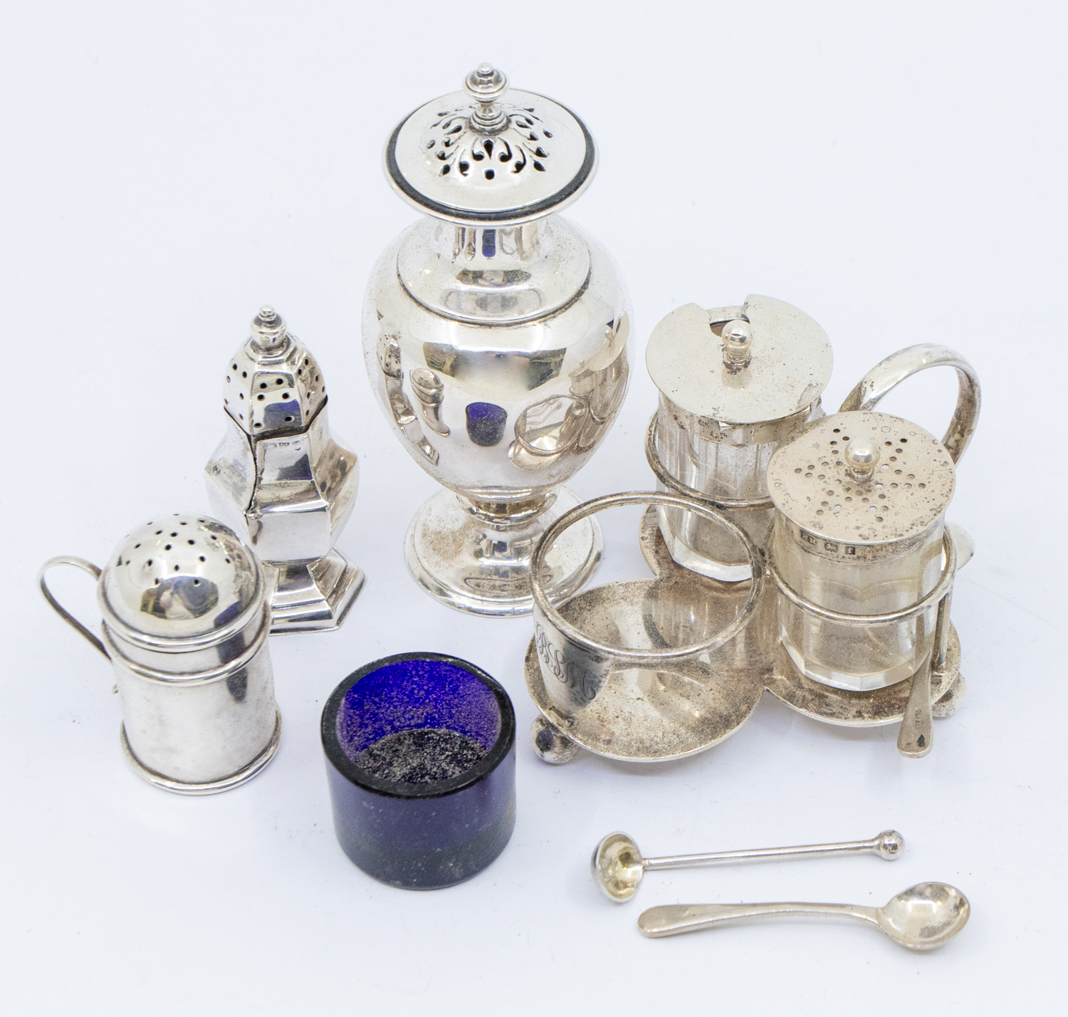A collection of various silver condiments to include:  1. A Victorian large urn shaped pepper pot,