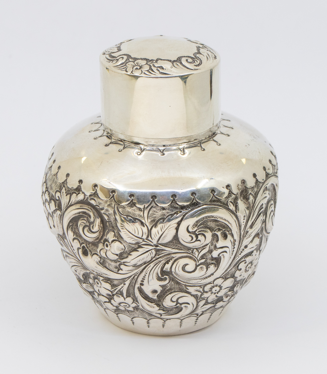 A Victorian silver tea caddy, of globular shape with elaborate floral and foliage repousse design,