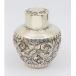 A Victorian silver tea caddy, of globular shape with elaborate floral and foliage repousse design,