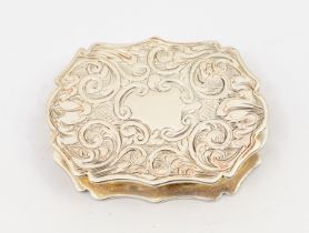 A Victorian silver cartouche shaped vinaigrette, profusely engraved with scrolling foliage, the
