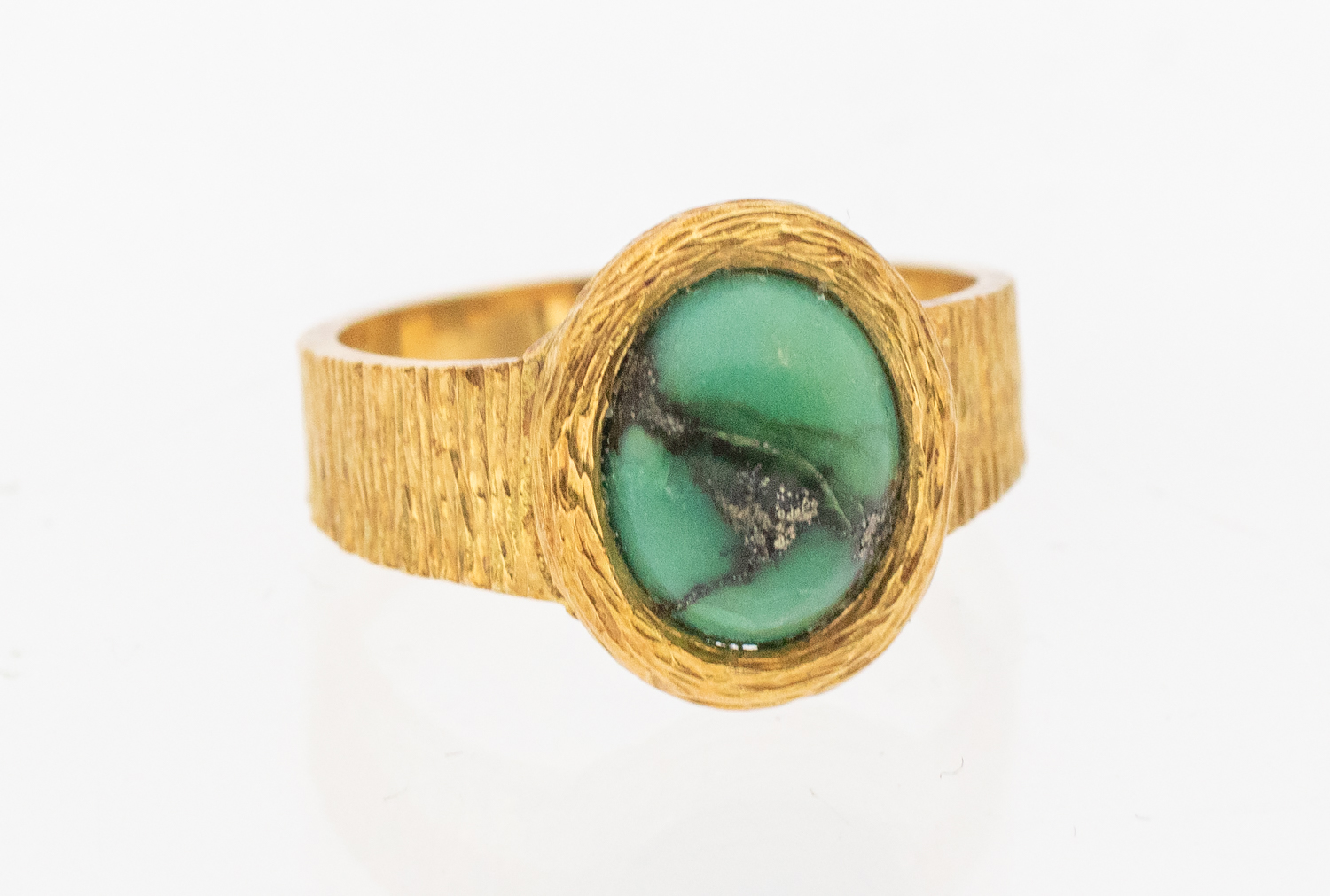 A turquoise 18ct gold ring, comprising an oval turquoise set to a bark textured band,width approx