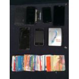 A collection of late 20th Century phone cards, i phones and other mobile phones and Sony walkman.