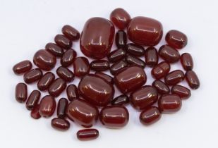 A collection of loose cherry amber type oval beads, the largest approx 24mm, the smallest approx