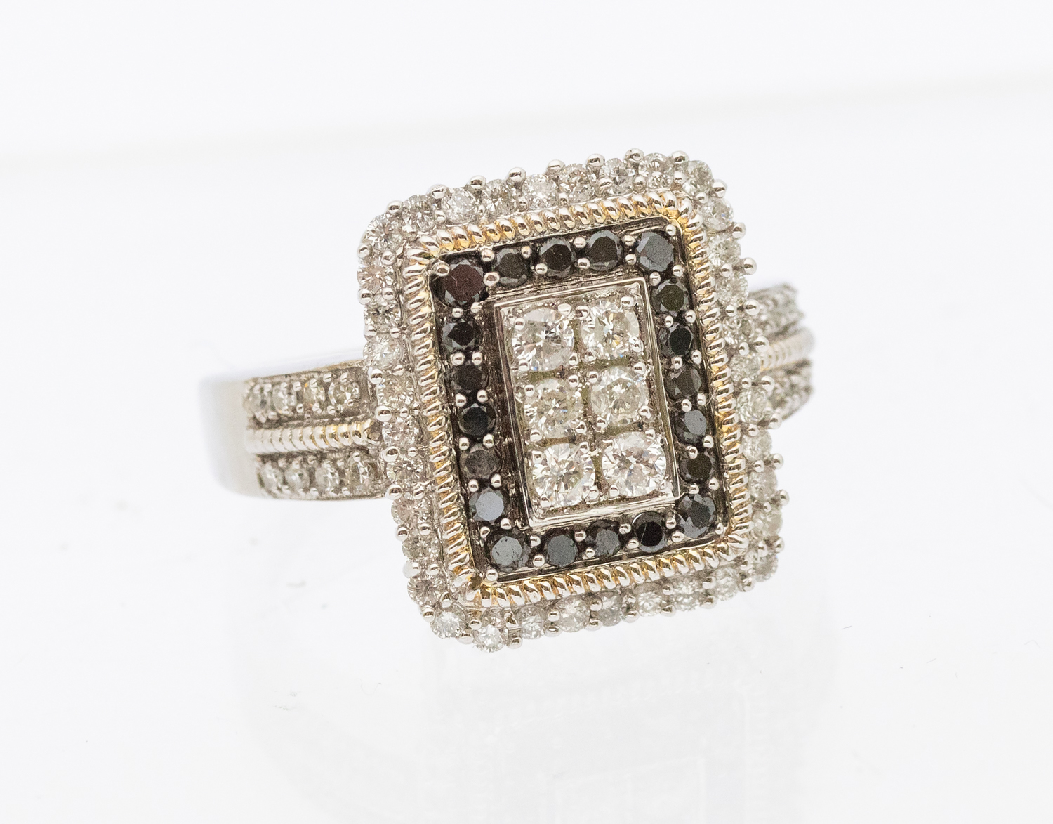 A black and white diamond white gold ring, comprising a rectangular mount, set to the centre with