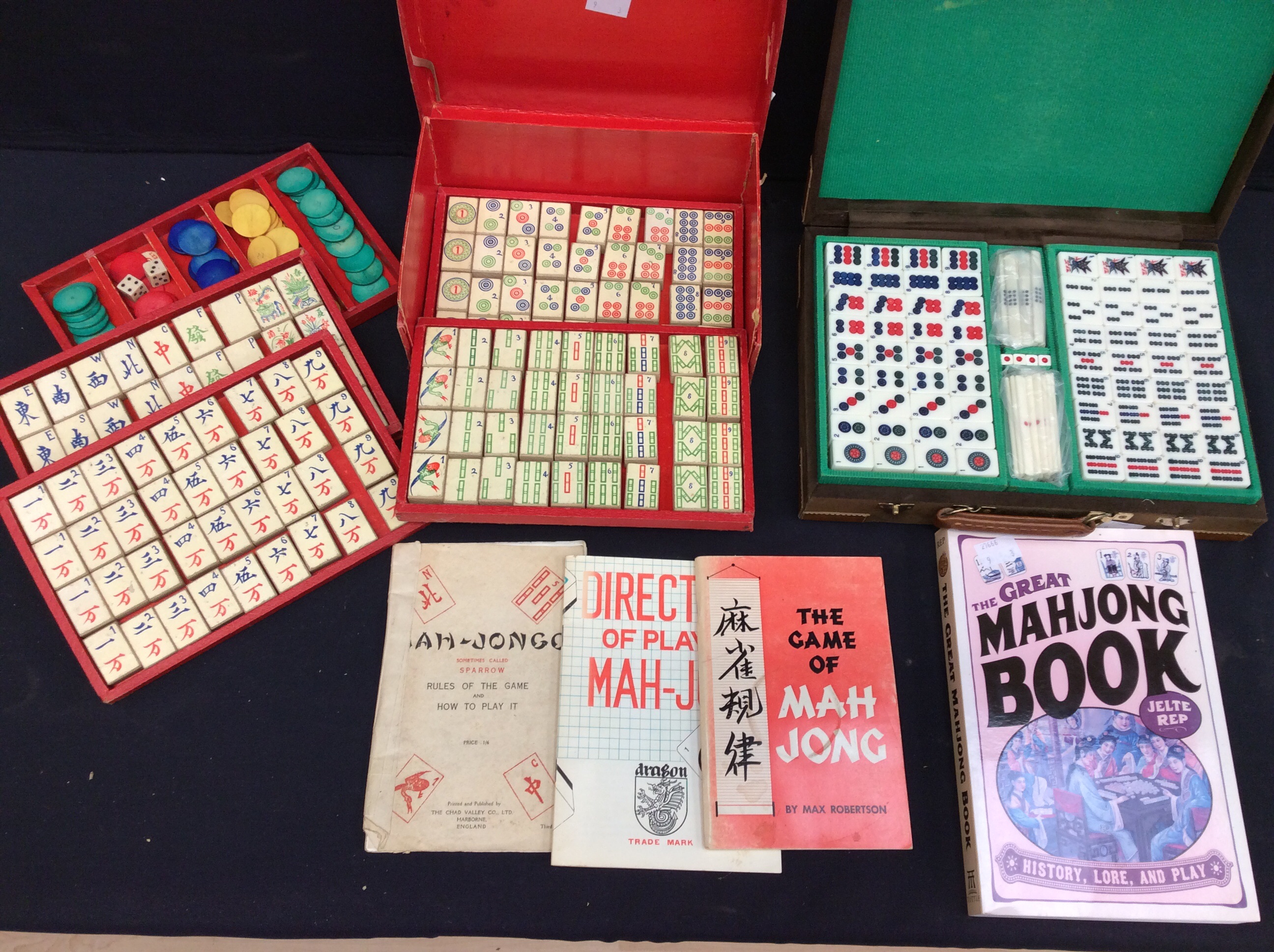 A 20th century Mahjong set in red paper case, pieces made of bone, different coloured pieces, along