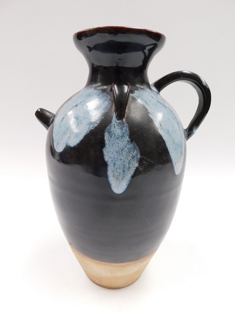 A Chinese Tang Dynasty style phosphatic splash brown glazed ewer, the ovoid body with large loop