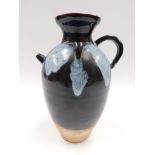 A Chinese Tang Dynasty style phosphatic splash brown glazed ewer, the ovoid body with large loop