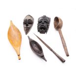 A collection of African treen items to include masks, bowls and water spoon along with a spearhead.