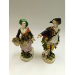 A pair of 18th century English porcelain figures of a boy and girl with sheep and his dog, minor