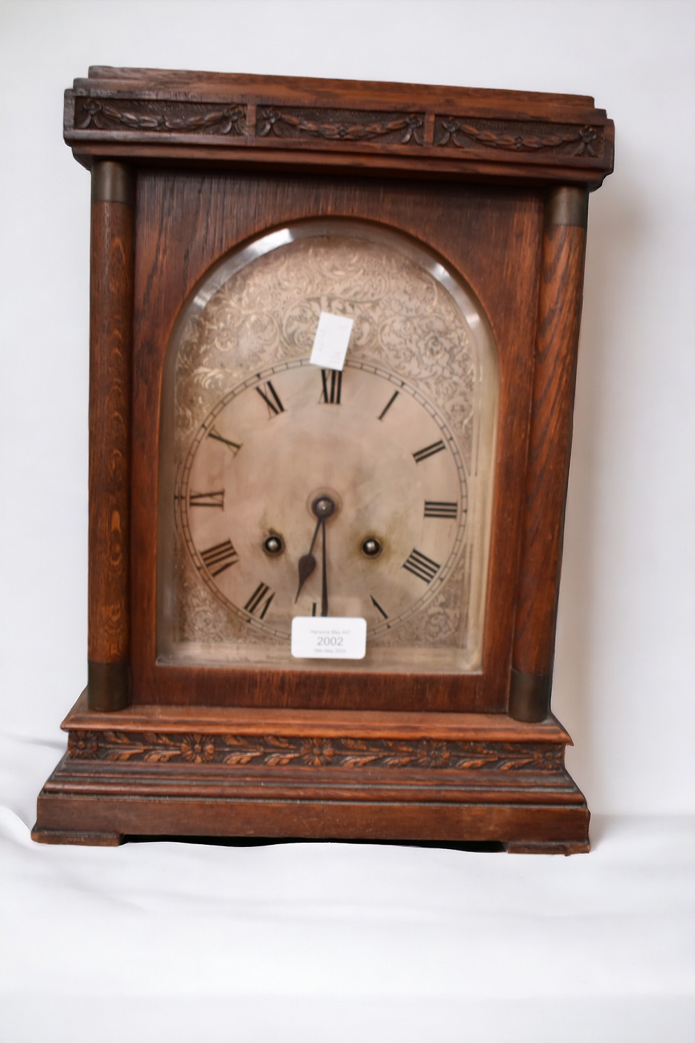 A 19th Century oak eight day mantle clock with silvered arched dial and Roman numerals.