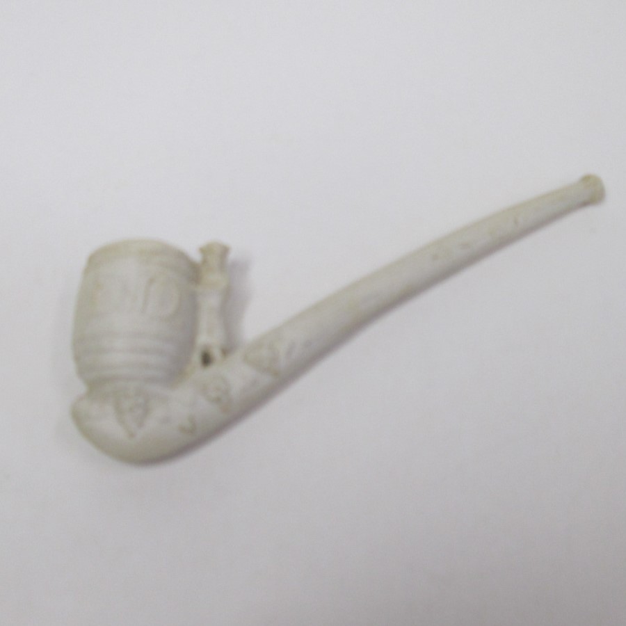 A Clay pipe with a wine barrel marked ‘DD’ and man standing at the side and applied grape