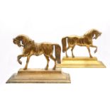 A pair of brass doorstops in the form of horses.