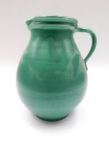 A large green 1930s water jug by C.H. Brannam.