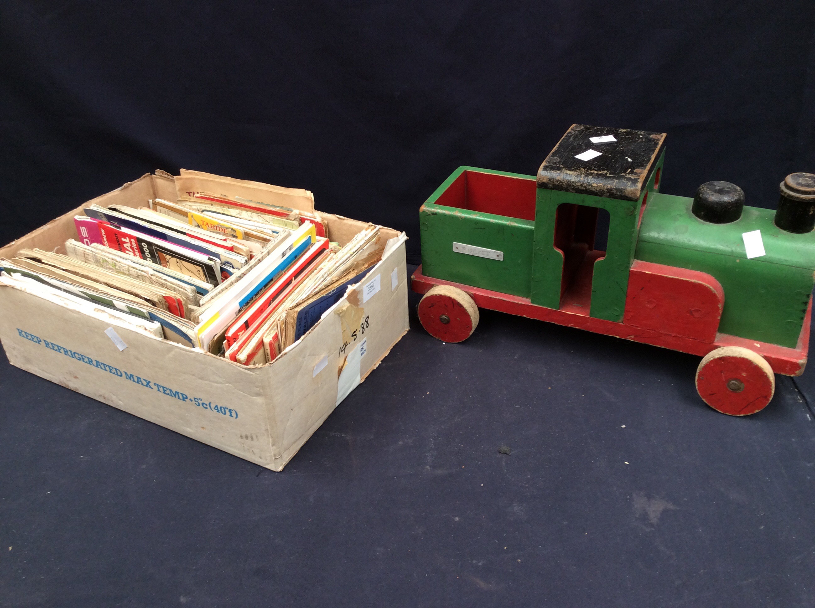 A collection of vintage road maps and a child's wooden train.