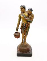 A figure of a native woman holding a child on stand.