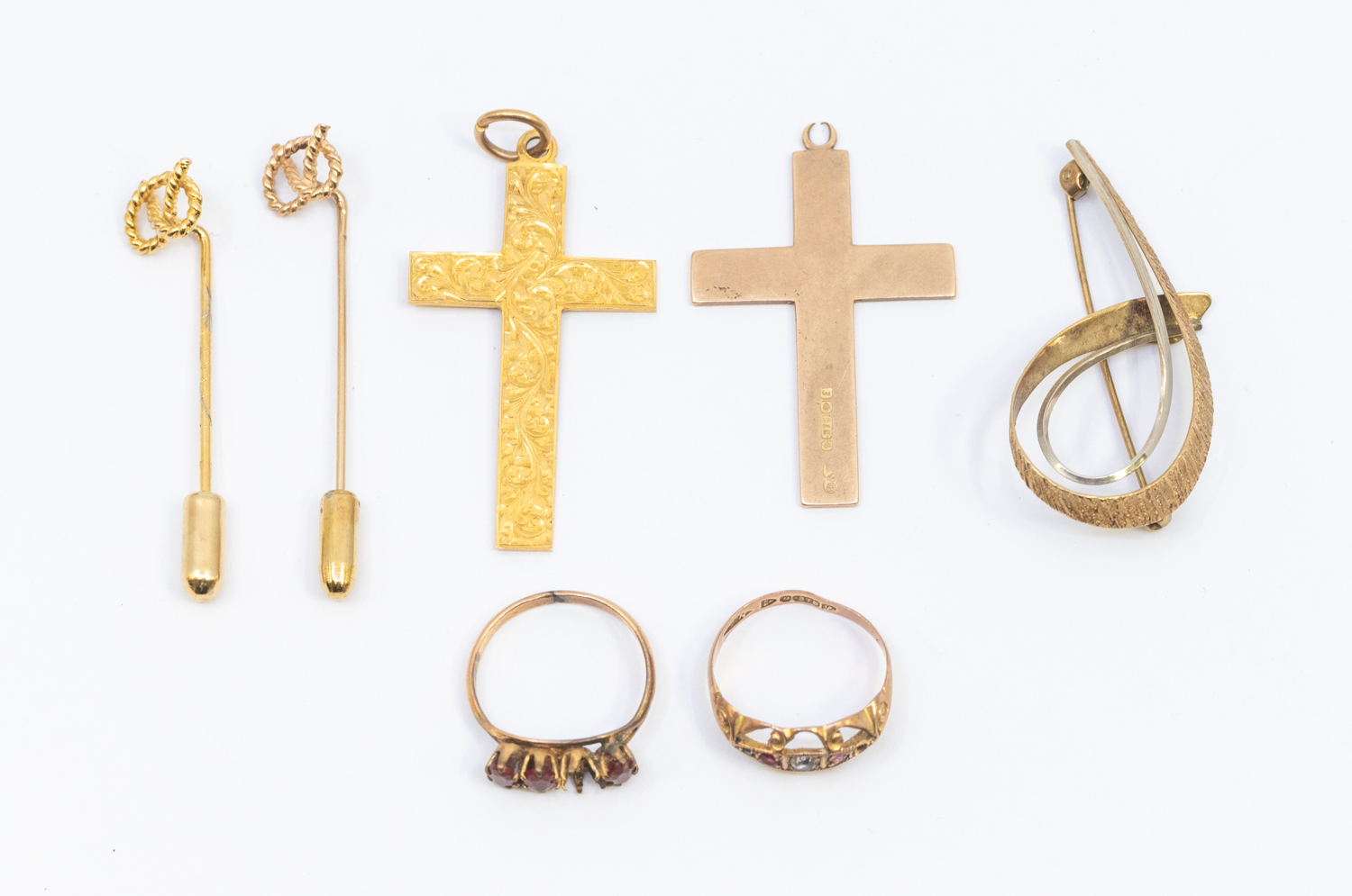 A collection of 9ct gold jewellery to include a floral engraved cross, rose gold cross a/f loop