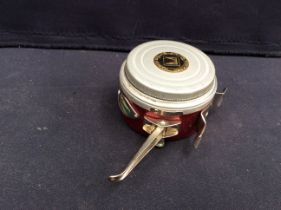 A Martin (USA) automatic Mohawk fishing reel, in metallic red colourway, in case.