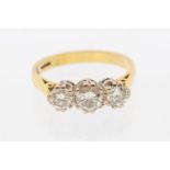 A three stone diamond and 18ct gold ring, the central diamond weighing approx  0.44ct, the outer