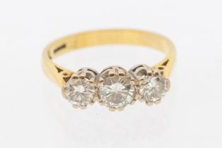 A three stone diamond and 18ct gold ring, the central diamond weighing approx  0.44ct, the outer