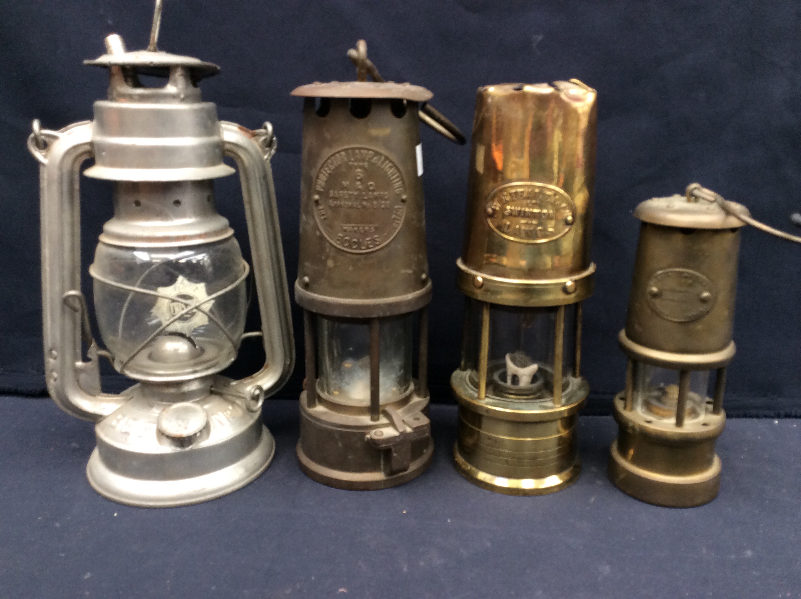 An Eccles miners lamp, small lamp and Limelight Company lamp, W.E Teale & Co lamp and an oil lamp.