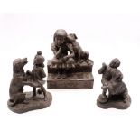 Three bronzed figures of children with dogs.